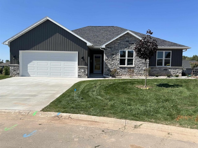 craftsman inspired home featuring a garage and a front lawn