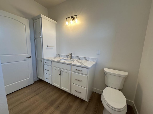 bathroom with hardwood / wood-style flooring, vanity, and toilet