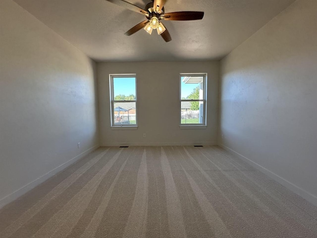 unfurnished room with light colored carpet, a textured ceiling, and ceiling fan