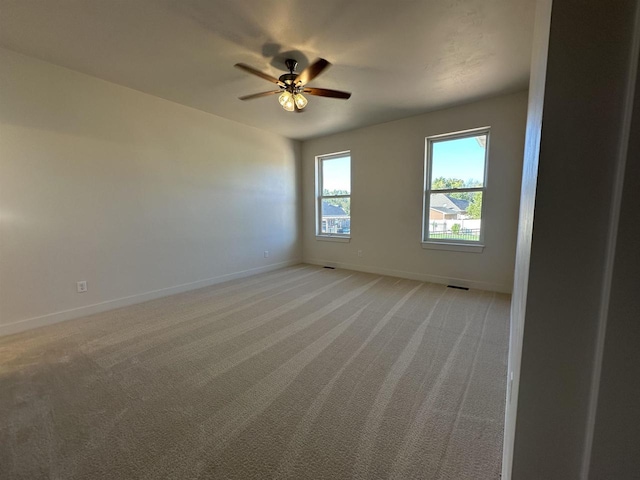 unfurnished room featuring light colored carpet and ceiling fan