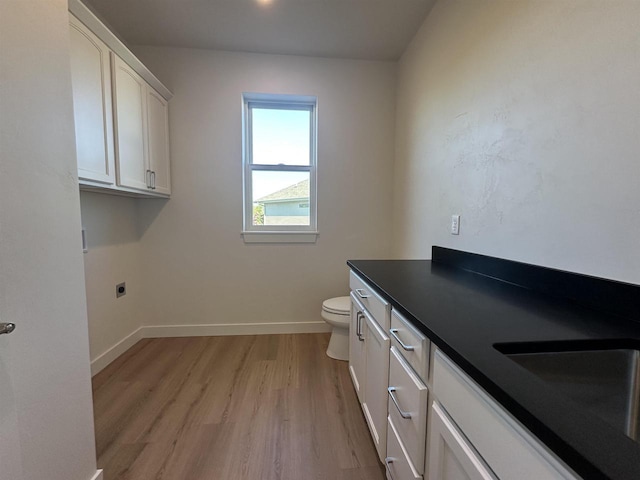 bathroom featuring wood-type flooring, toilet, and vanity