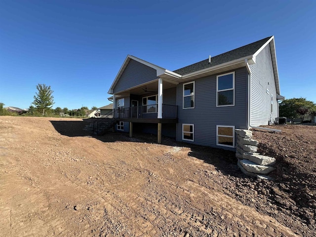 rear view of property featuring central AC unit and ceiling fan