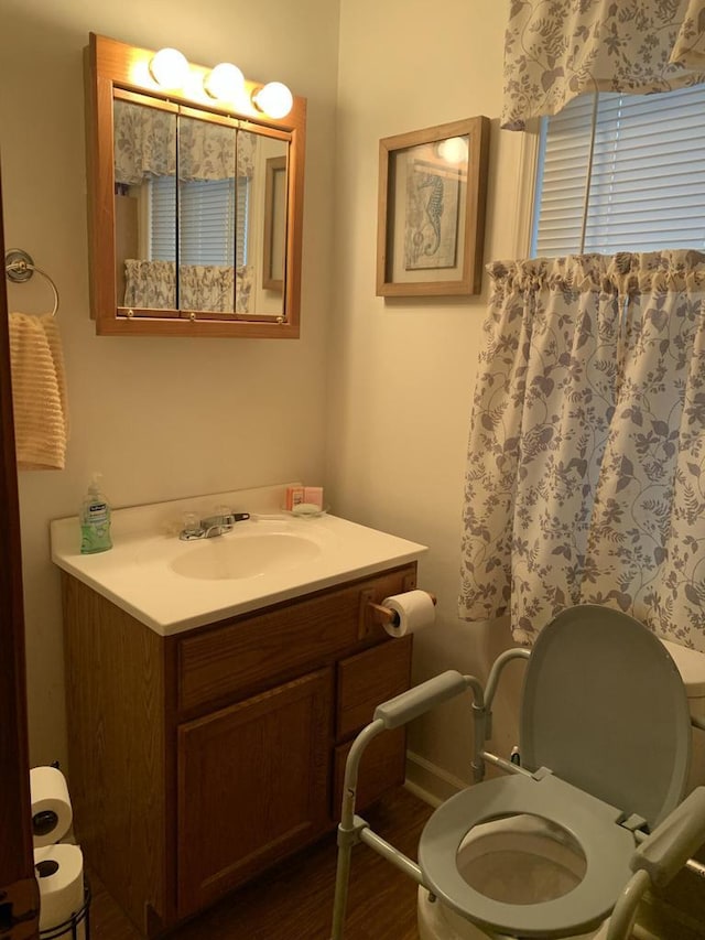 bathroom with vanity, wood-type flooring, and toilet