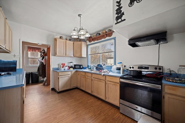 kitchen featuring hanging light fixtures, range hood, light hardwood / wood-style floors, and stainless steel electric range oven