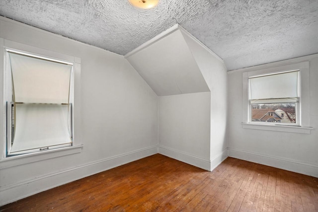 bonus room featuring lofted ceiling, hardwood / wood-style floors, and a textured ceiling