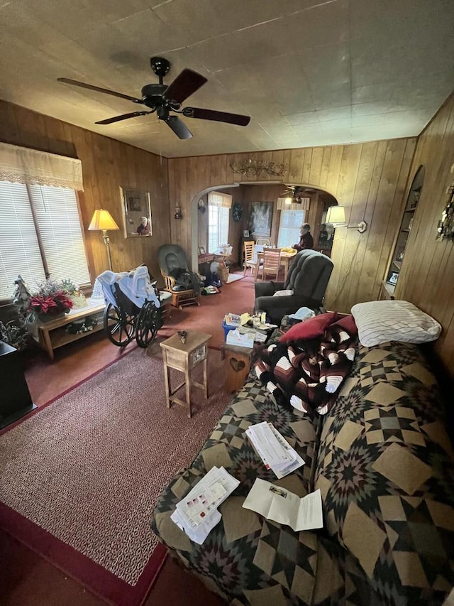 carpeted bedroom with ceiling fan and wooden walls