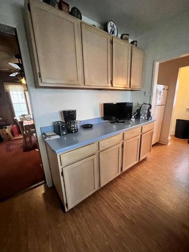 kitchen with light brown cabinetry, light hardwood / wood-style flooring, and white refrigerator