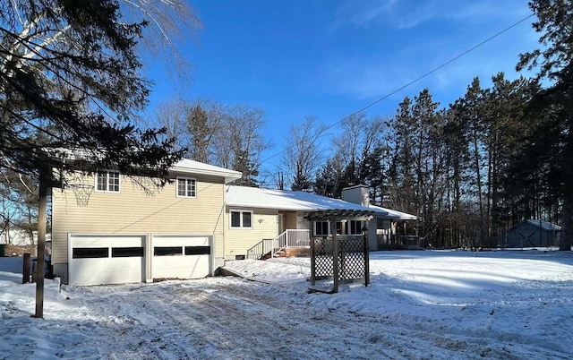 view of snow covered exterior with a garage