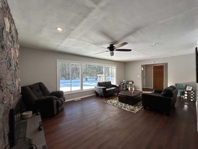 living room featuring dark wood-type flooring and ceiling fan