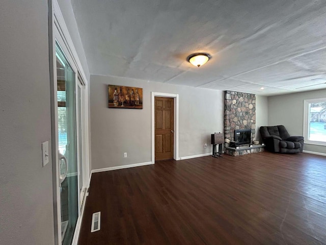 unfurnished room featuring dark wood-type flooring and a fireplace