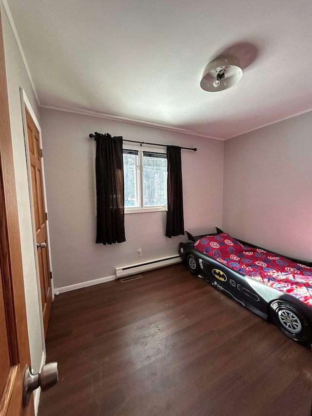 unfurnished bedroom featuring baseboard heating, dark hardwood / wood-style floors, and crown molding