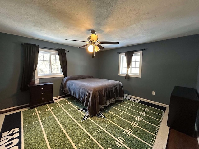 bedroom featuring multiple windows, ceiling fan, and a textured ceiling