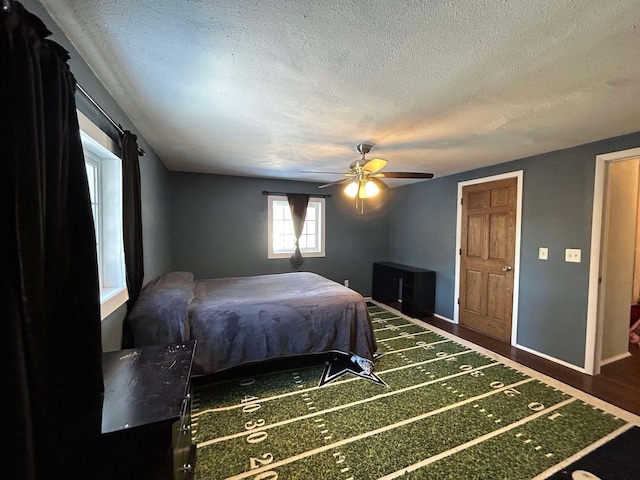 bedroom featuring a textured ceiling, dark hardwood / wood-style floors, and ceiling fan