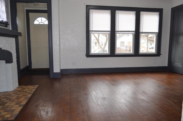 entrance foyer featuring dark wood-type flooring and a wealth of natural light