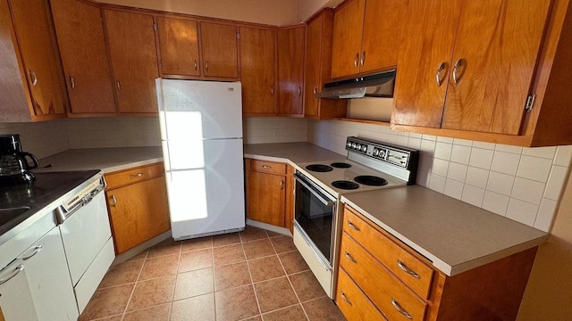 kitchen featuring backsplash, white appliances, and dark tile patterned floors