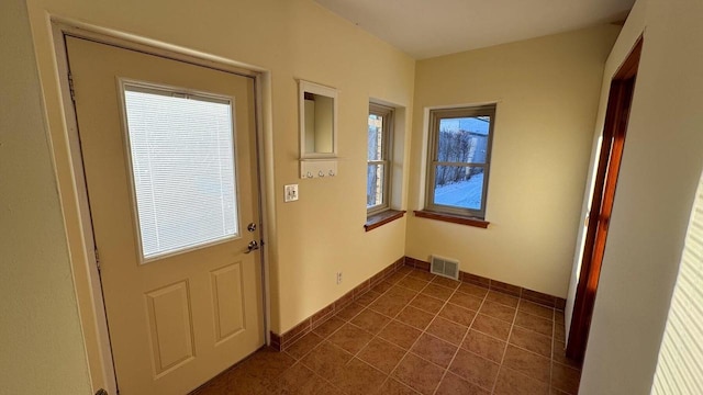 doorway to outside featuring dark tile patterned flooring