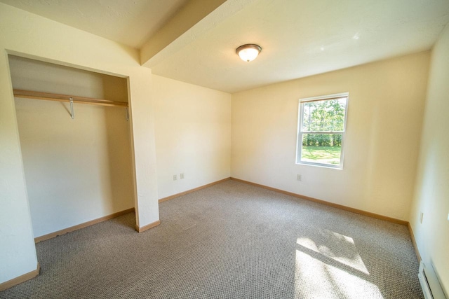 unfurnished bedroom featuring baseboard heating, carpet flooring, and a closet