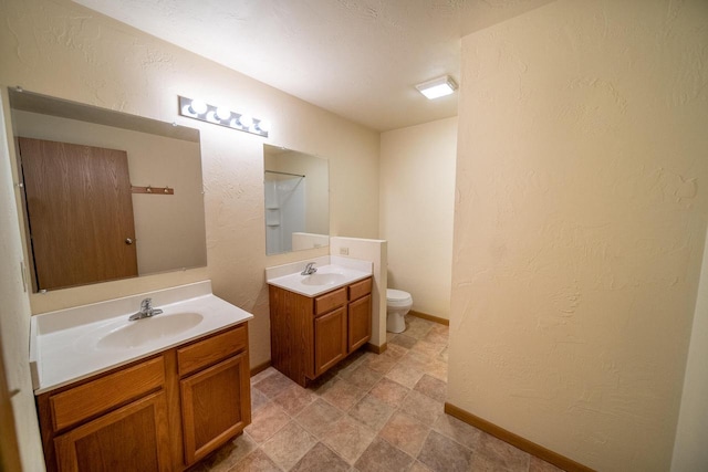 bathroom featuring two vanities, a textured wall, and a sink