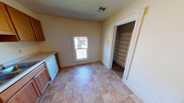 kitchen featuring light countertops, white dishwasher, visible vents, and brown cabinets