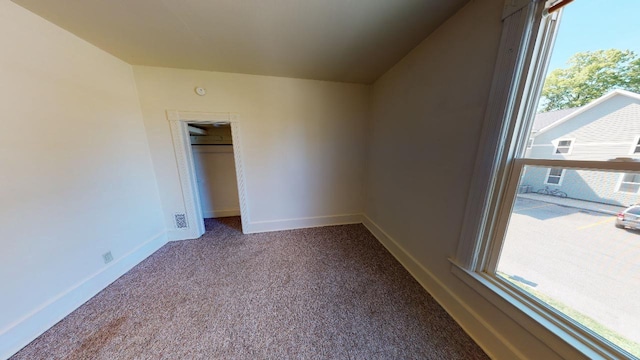 unfurnished bedroom featuring carpet floors, baseboards, and a closet