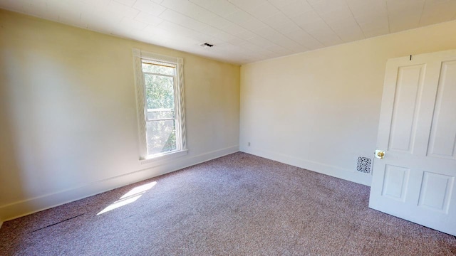 carpeted empty room with visible vents and baseboards