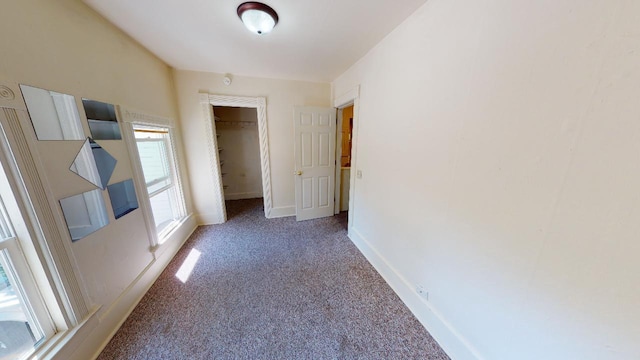 spare room featuring carpet and baseboards