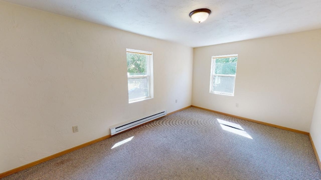 carpeted spare room featuring a baseboard radiator and baseboards