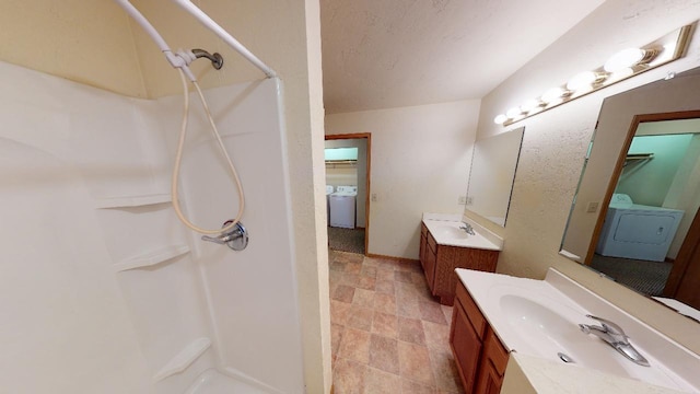 bathroom with vanity, washer / dryer, a textured ceiling, and walk in shower