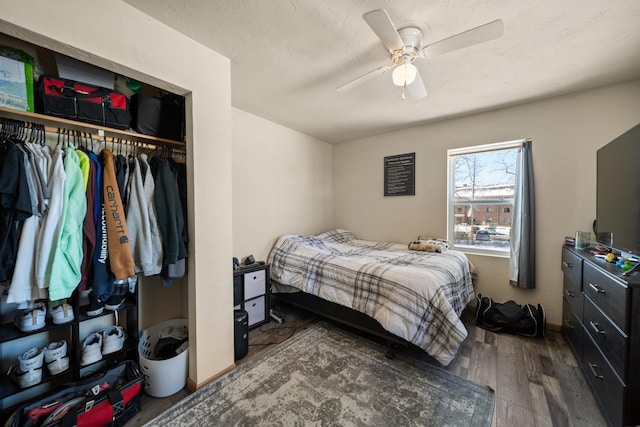 bedroom featuring ceiling fan, a closet, dark wood finished floors, and a textured ceiling