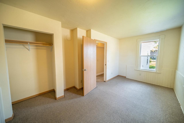 unfurnished bedroom with light carpet, a closet, and a textured ceiling