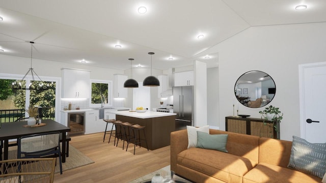 living room featuring wine cooler, vaulted ceiling, and light hardwood / wood-style floors