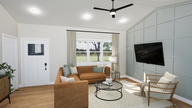 living room with ceiling fan, vaulted ceiling, and light hardwood / wood-style flooring