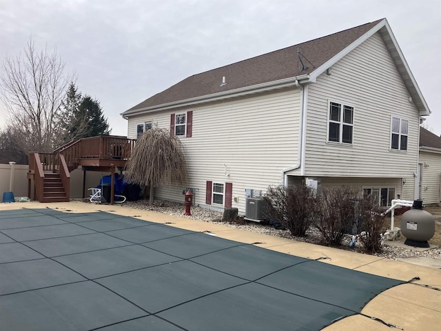 back of property featuring a swimming pool side deck and central AC unit