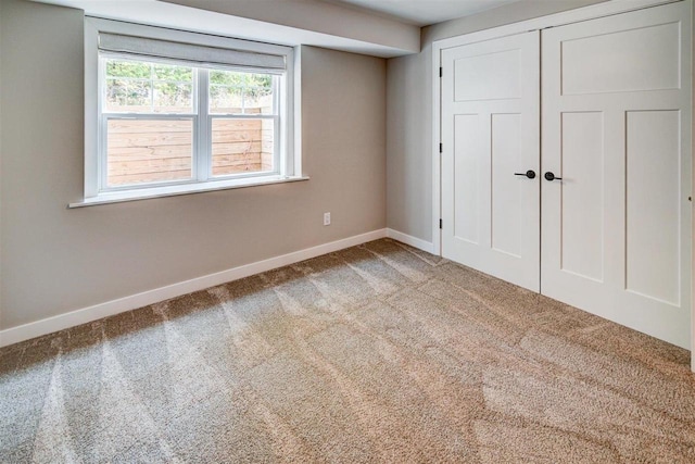 unfurnished bedroom with light carpet and a closet