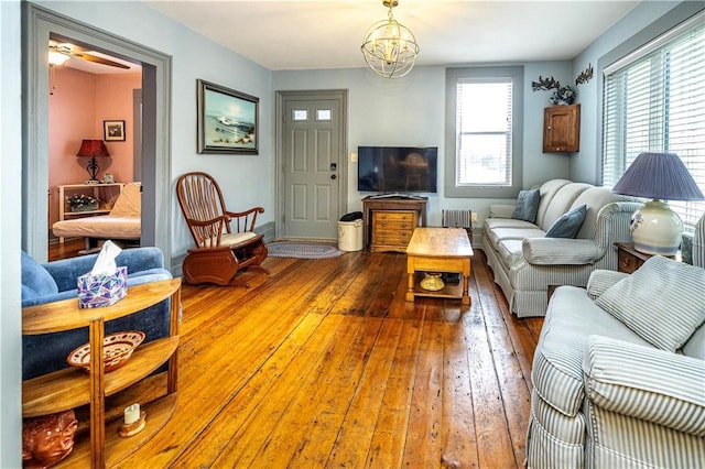 living room featuring radiator heating unit, wood-type flooring, and a chandelier