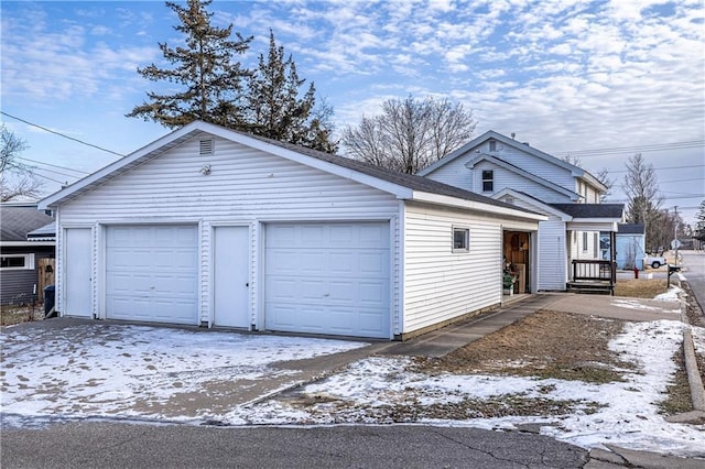 view of front of house featuring a garage and an outbuilding