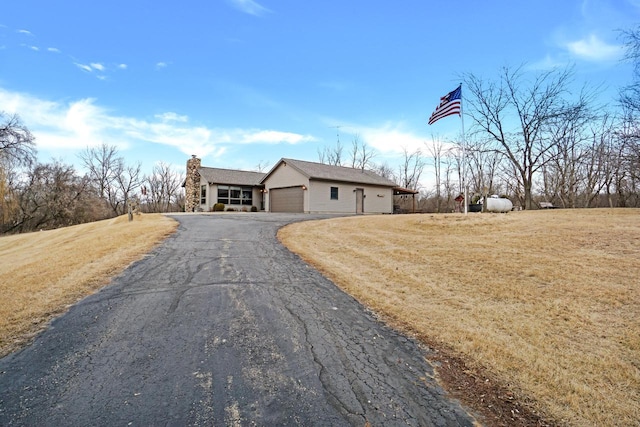 ranch-style home featuring a garage and a front yard