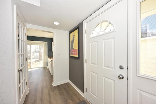 foyer featuring dark wood-type flooring and a textured ceiling