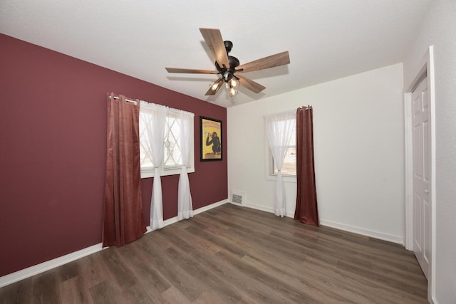 unfurnished bedroom featuring dark wood-type flooring and ceiling fan