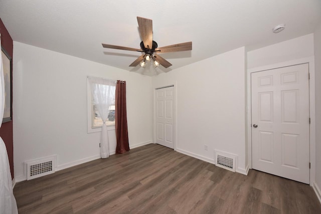 unfurnished bedroom featuring dark hardwood / wood-style flooring, a closet, and ceiling fan