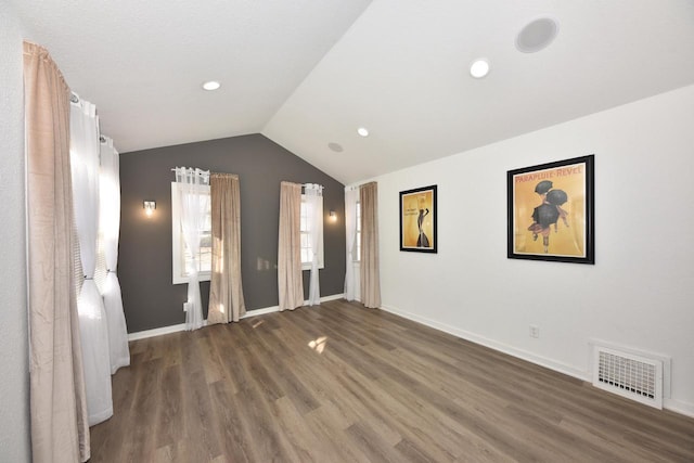 unfurnished bedroom featuring vaulted ceiling and dark hardwood / wood-style flooring