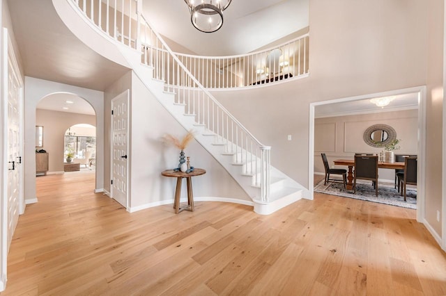 entrance foyer featuring hardwood / wood-style flooring, a chandelier, and a high ceiling