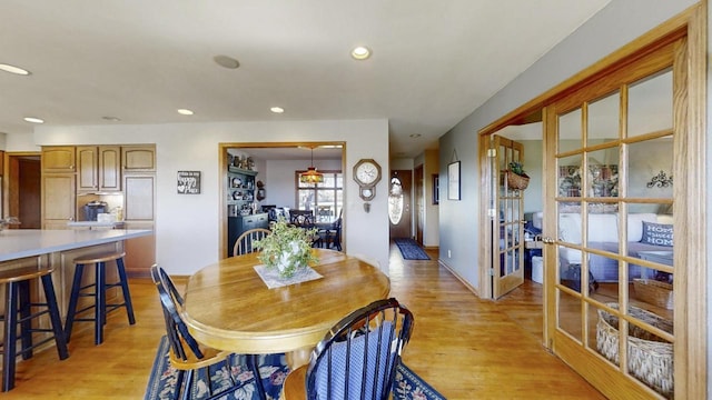 dining space with light hardwood / wood-style floors and french doors