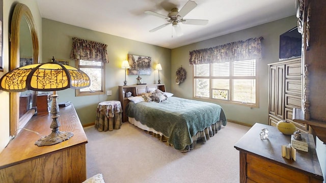 carpeted bedroom featuring multiple windows and ceiling fan