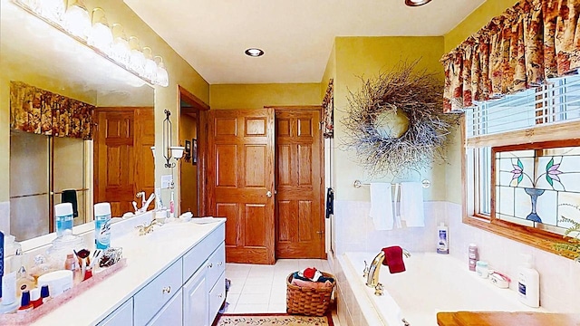 bathroom with vanity, tiled bath, and tile patterned floors