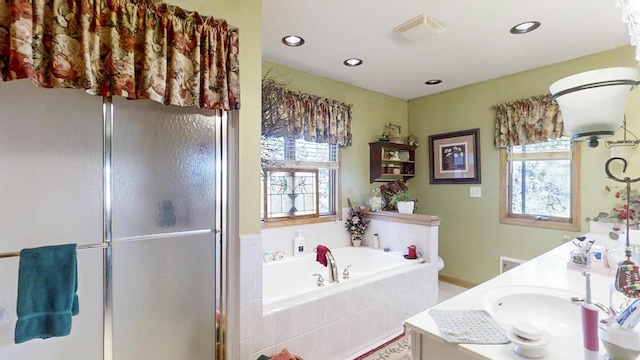 bathroom with vanity, separate shower and tub, and a wealth of natural light