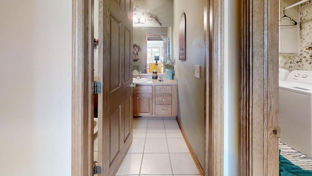 hallway featuring washer / clothes dryer, light tile patterned flooring, and sink