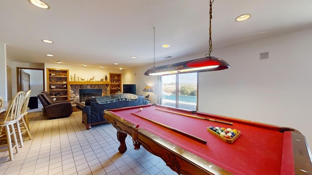 game room with pool table, a fireplace, and light tile patterned flooring