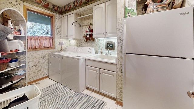 laundry area with sink, washing machine and dryer, cabinets, and light tile patterned flooring