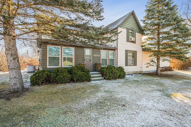 view of front property featuring cooling unit and a front yard